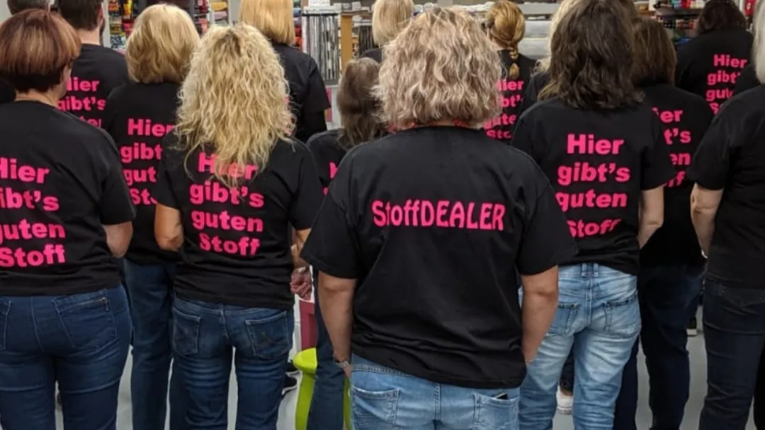 Das Team von Hager Stoffe in schwarzen T-Shirts mit der Aufschrift „Hier gibt's guten Stoff“